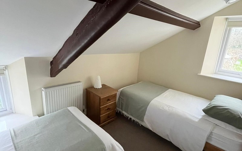 Harford House Twin Bedroom Bedroom floor is carpeted and the ceiling slopes down to 3ft (100 cm) approx above floor.  Access to room is by ascending from a half landing with three steps each 7in (19cm) with handrails either side.